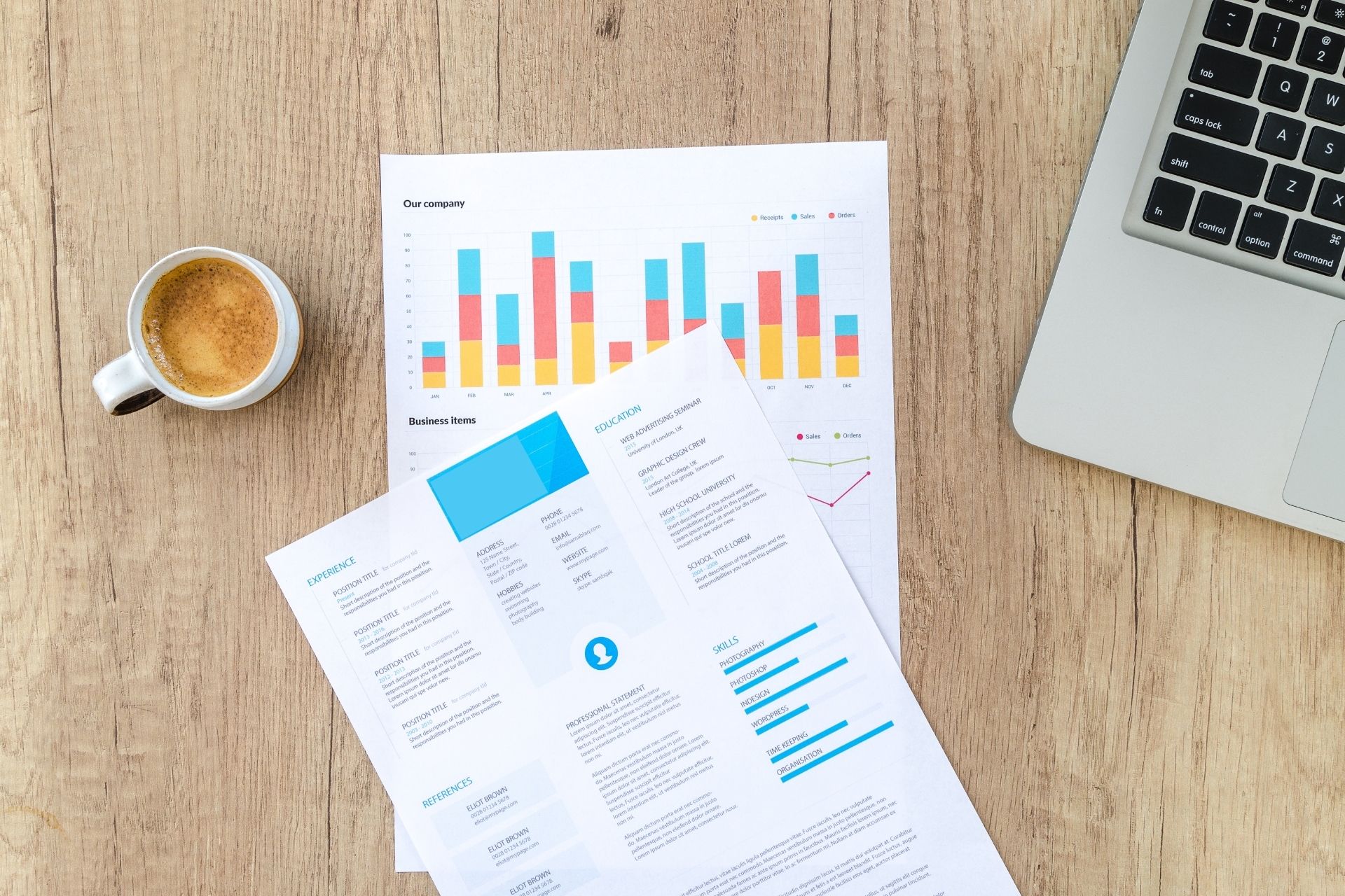 Document Management print out of resume and bar chart sitting on a desk with coffee in a cup to the left and apple laptop to the right