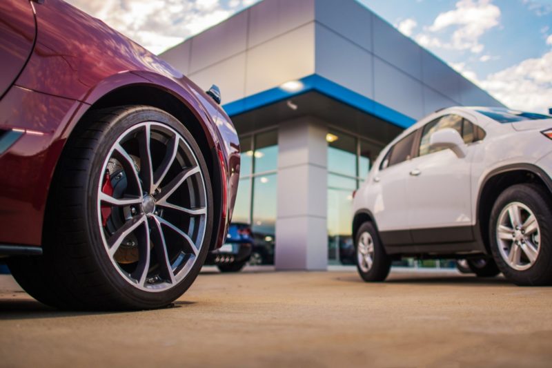 closeup of two vehicles on a car dealership car lot